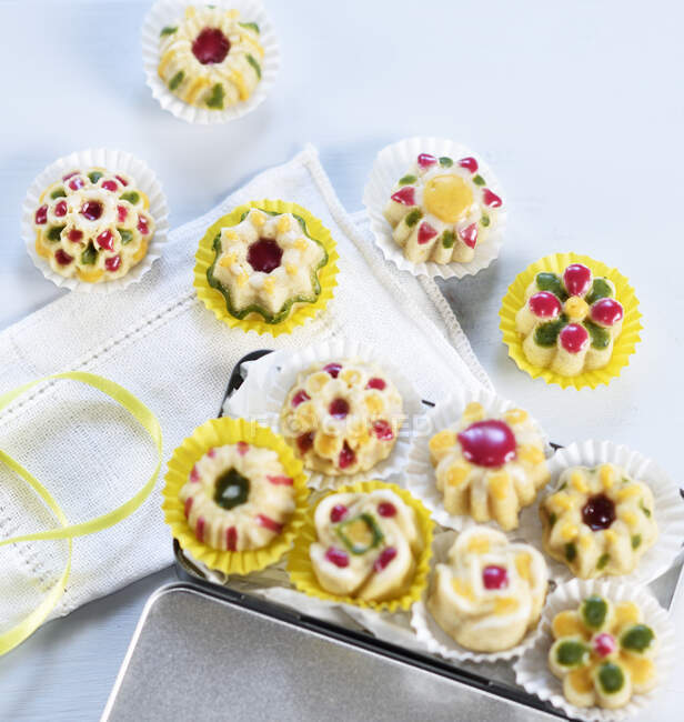 Mini pasteles con glaseado colorido en estuches de papel (vegetariano) - foto de stock