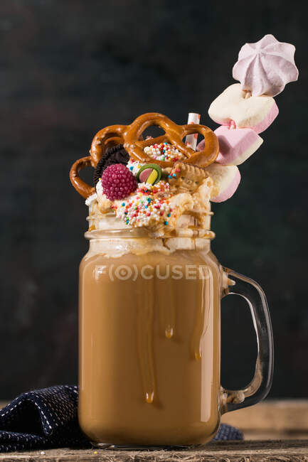 Um abanão com café, creme e doces coloridos — Fotografia de Stock
