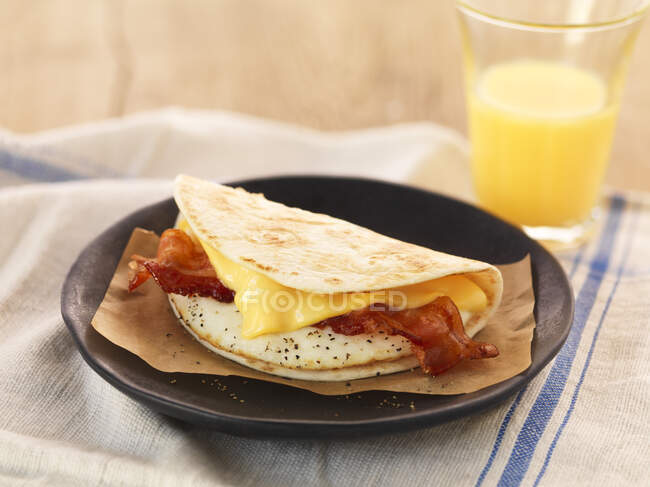 Omelette de petit déjeuner avec bacon et fromage servi dans une assiette — Photo de stock