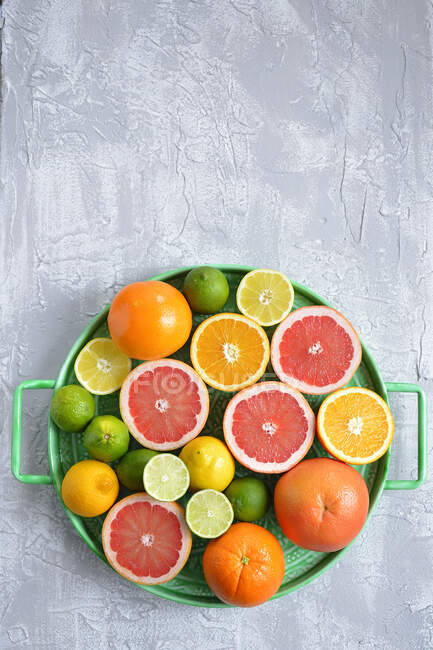 Апельсини грейпфрут обмежує лимони на лотку коктейлю цитрусових — стокове фото