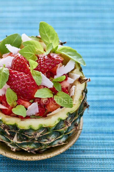 Fruit salad with strawberries served in a hollowed-out pineapple — Stock Photo