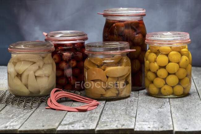 Збережені фрукти (свинки, вишні, сливи, маленькі жовті сливи та яблуко ) — стокове фото