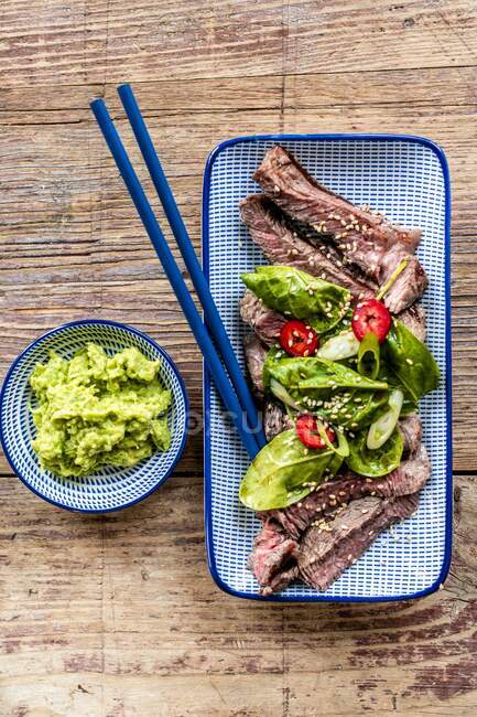 Steak with spinach leaves and a wasabi-avocado dip (Japan) — Stock Photo