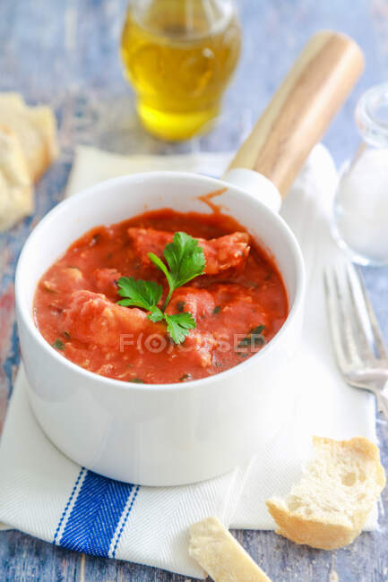 Bacalao en salsa de tomate con cebolla y perejil - foto de stock