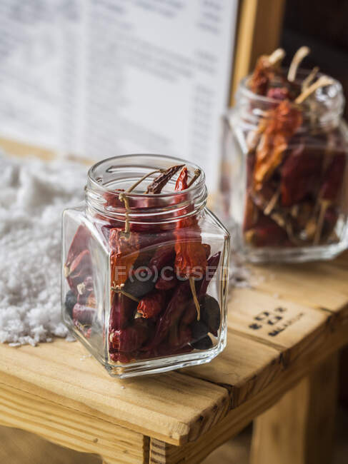 Dried red chili peppers in screw top jars — Stock Photo