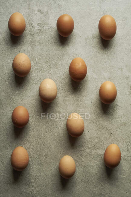 Brown eggs on gray surface, top view — Stock Photo