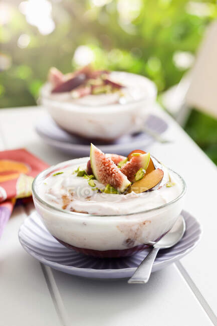 Yoghurt with berry compote, figs and pistachios — Stock Photo