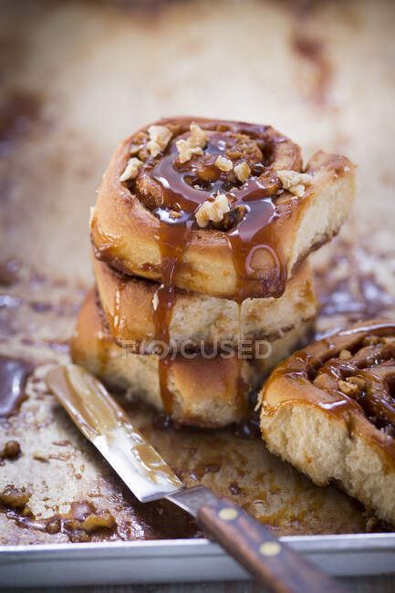 Cinnamon rolls with chopped nuts and caramel sauce — Stock Photo