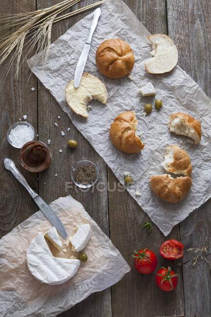 Breakfast with bread rolls, brie and tomatoes — Stock Photo