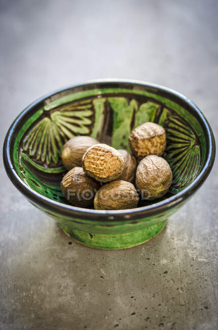 Nutmegs en un tazón pequeño - foto de stock