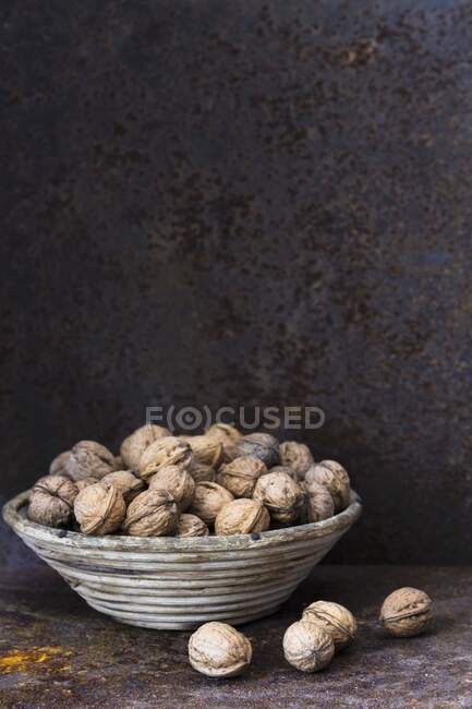 Волоські горіхи в кошику на стіні сільського металу — стокове фото