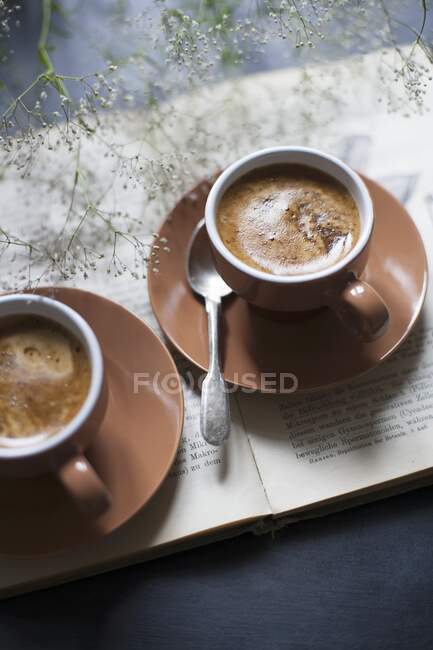 Two Espressotassen on book — Stock Photo