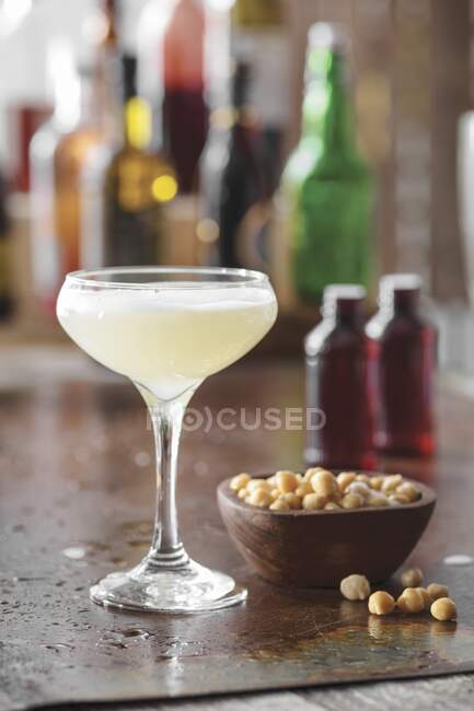 Chickpea aquafaba Cocktail in glass and chickpeas in bowl on table — Stock Photo