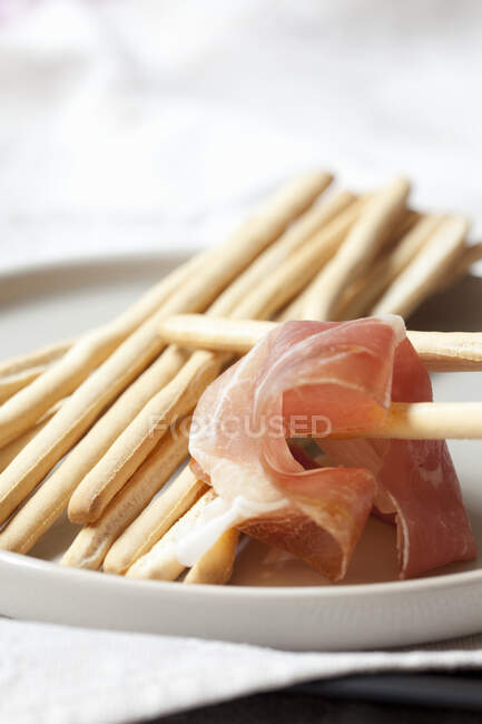 Parma ham with grissini, close up shot — Stock Photo