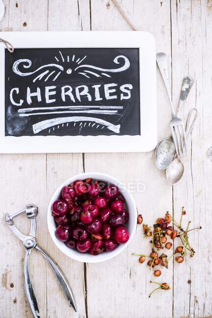 Stoned cherries with a slate sign — Stock Photo