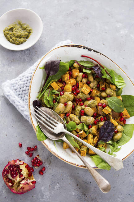Vegetable salad with butter beans, sweet potatoes, pomegranate seeds and pesto — Stock Photo