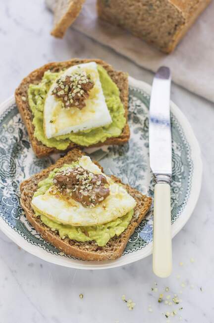 Toasts with avocado cream and fried eggs — Stock Photo