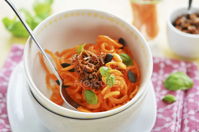 Karottenspaghetti mit getrocknetem Tomatenpesto, Kürbiskernen und frischem Basilikum — Stockfoto