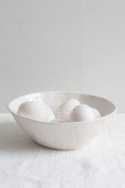 White ceramic bowl with white eggs — Stock Photo