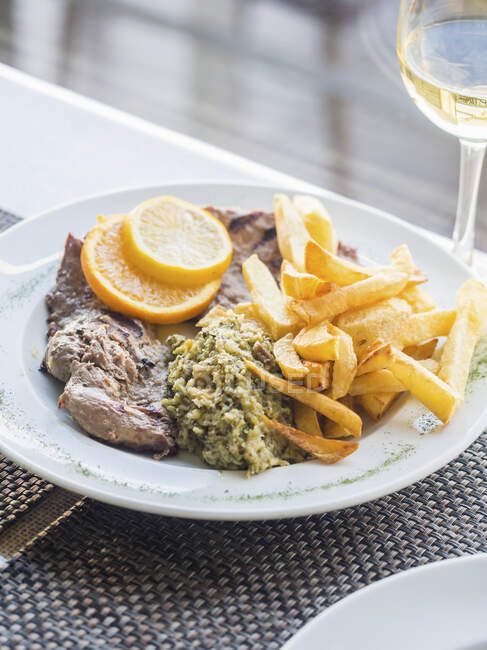 Fillet of Iberico pork with spinach migas and chips (Portugal) — Stock Photo