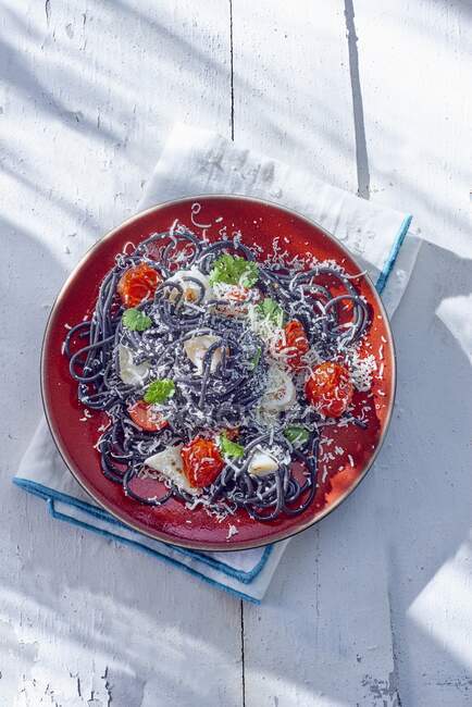 Black spaghetti with squid and tomatoes — Stock Photo