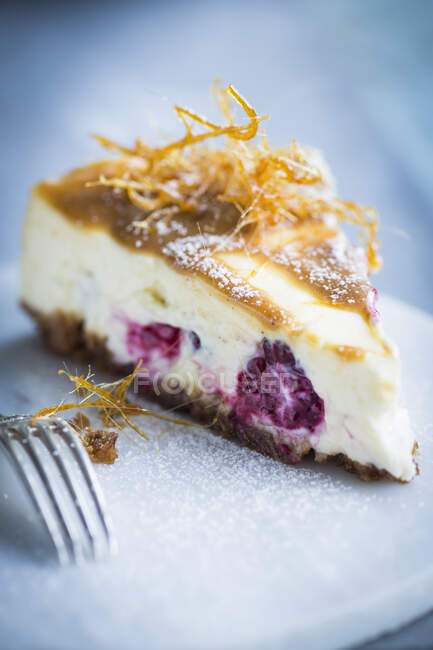 Una rebanada de pastel de queso con frambuesas - foto de stock