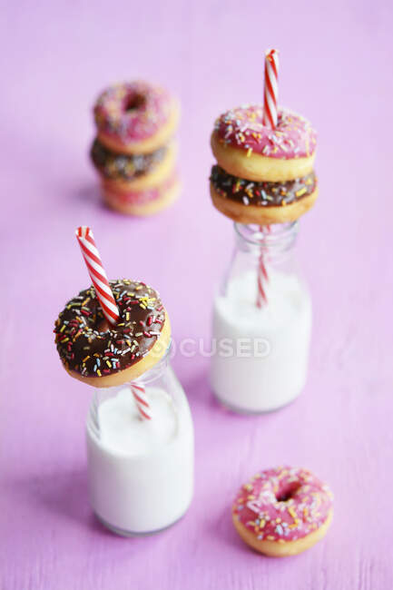 Mini donuts com gelo e fios de açúcar, e leite vegan em garrafas — Fotografia de Stock