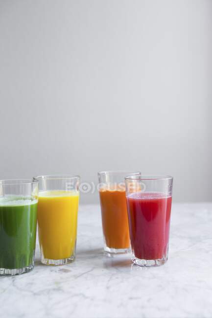 Various fresh cold-pressed juices (green juice, apple and lemon juice, carrot juice, watermelon juice) — Stock Photo