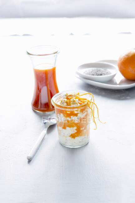 Ein Dessert aus Frischkäse, Sanddornsirup, Orangenfilets, Orangenschale und Chiasamen — Stockfoto