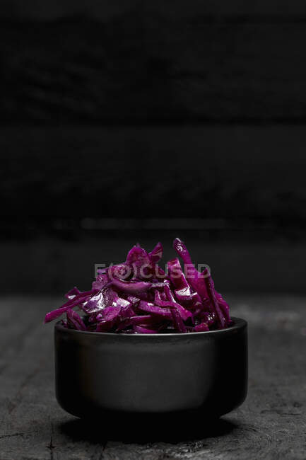 Red cabbage in a bowl on a wooden background — Stock Photo