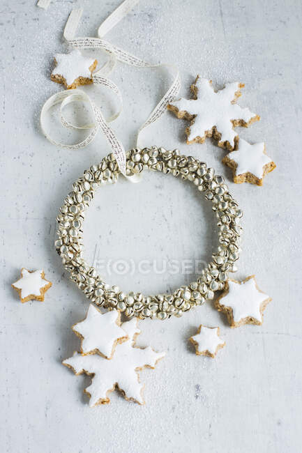 Una corona de Navidad y galletas estrella con glaseado blanco - foto de stock
