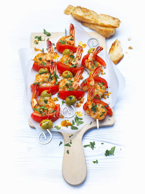 Scampi skewers with tomatoes and olives — Stock Photo