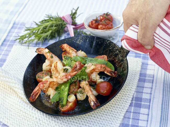 Prawns in a pan with sugar snap peas and cherry tomatoes — Stock Photo