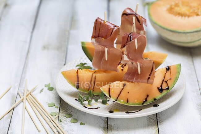 Serrano ham on melon with balsamic sauce — Stock Photo