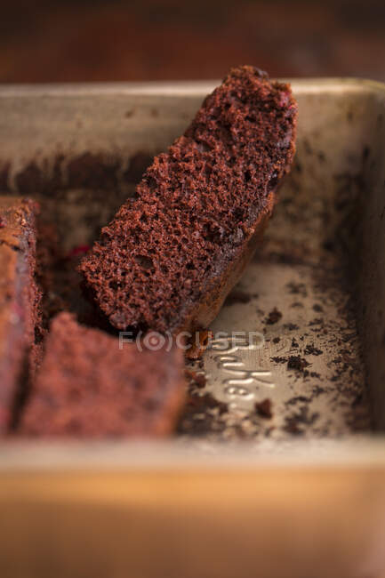Una rebanada de pastel de chocolate en una lata para hornear - foto de stock