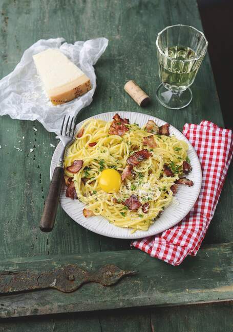 Spaghetti carbonara con jamón y yema de huevo - foto de stock