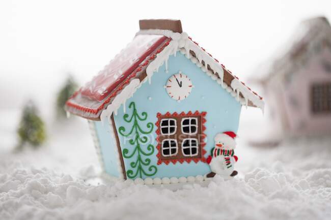 Casa de gengibre com glacê azul e boneco de neve comestível — Fotografia de Stock