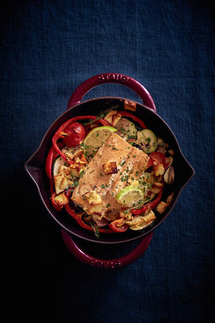 Salmon fillet with goat's cheese on bed of vegetables — Stock Photo
