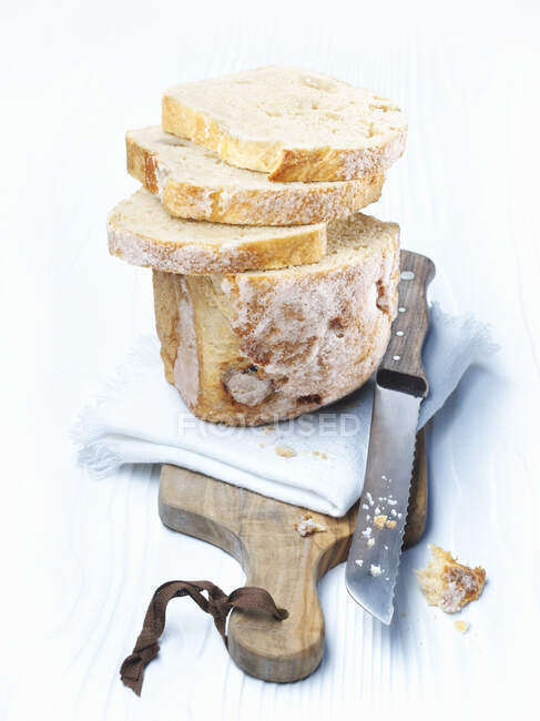 Pan dulce en tabla de cortar con cuchillo y tela - foto de stock