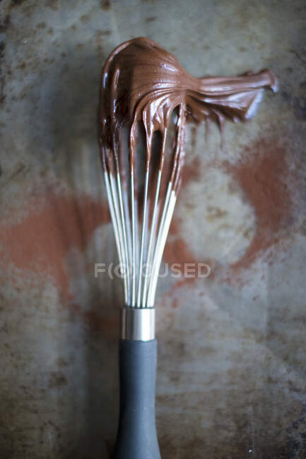 A whisk with chocolate cream (top view) — Stock Photo