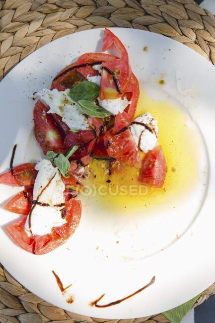 Tomatoes with mozzarella on a plate (top view) — Stock Photo