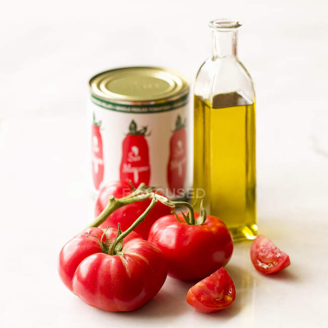 Simple tomato and olive oil still lfie on a white background — Stock Photo
