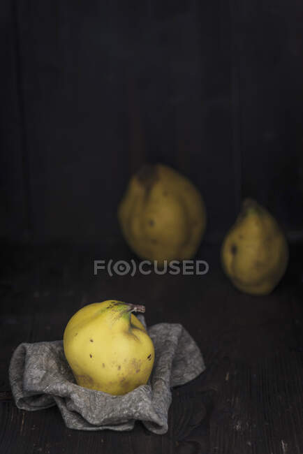 Quinces on a cloth and behind it — Stock Photo