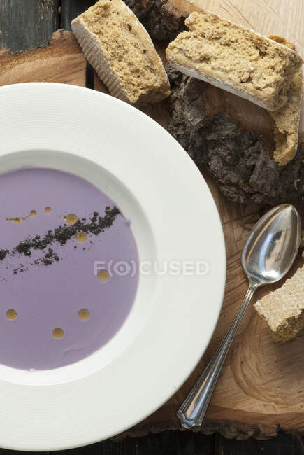 Sopa de coliflor púrpura servida con ruscos - foto de stock