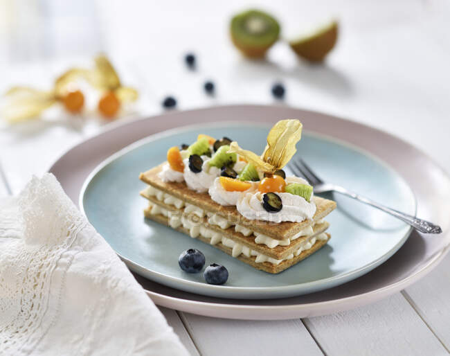 Mille feuille with vanilla cream, kiwis, blueberries and physalis (vegan) — Stock Photo