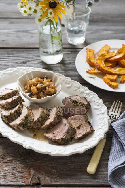 Pork loin with herbs, pear chutney and roasted pumpkin — Stock Photo