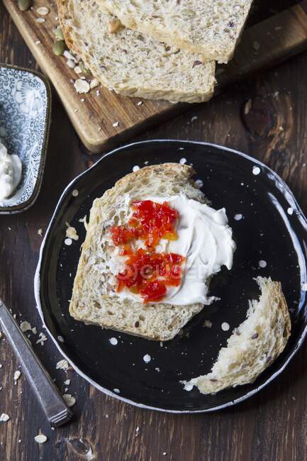 Slice of wholegrain bread with cream cheese and cilli jam — Stock Photo