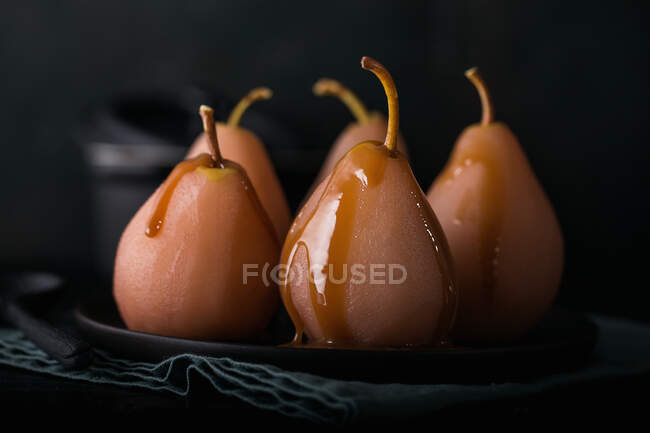 Pears cooked in red wine with caramel sauce for Christmas — Stock Photo