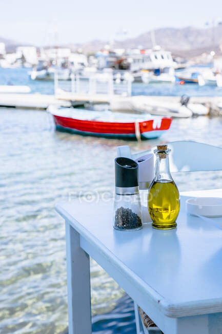 Oil, salt and pepper on a table beside beach — Stock Photo