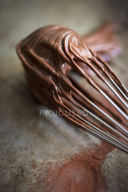 A whisk covered with chocolate cream — Stock Photo